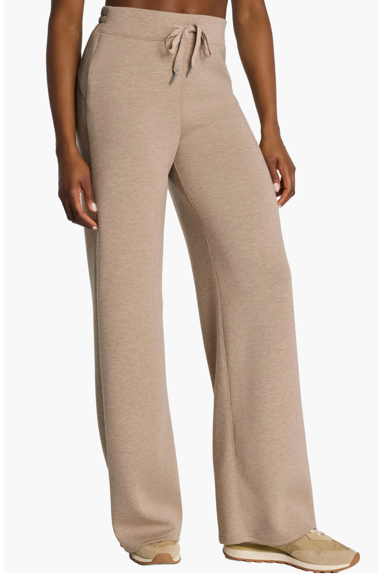 Beige lounge pants worn by a person on a white background