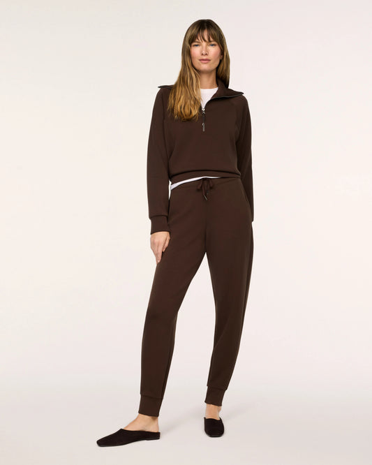 Model wearing Spanx Half Zip Umber Root with white background.