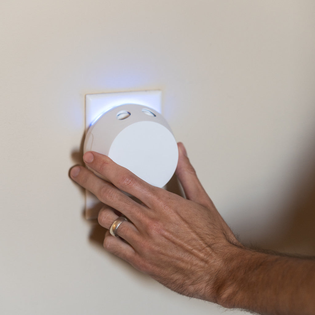 Hand plugging in a pura with a night light feature