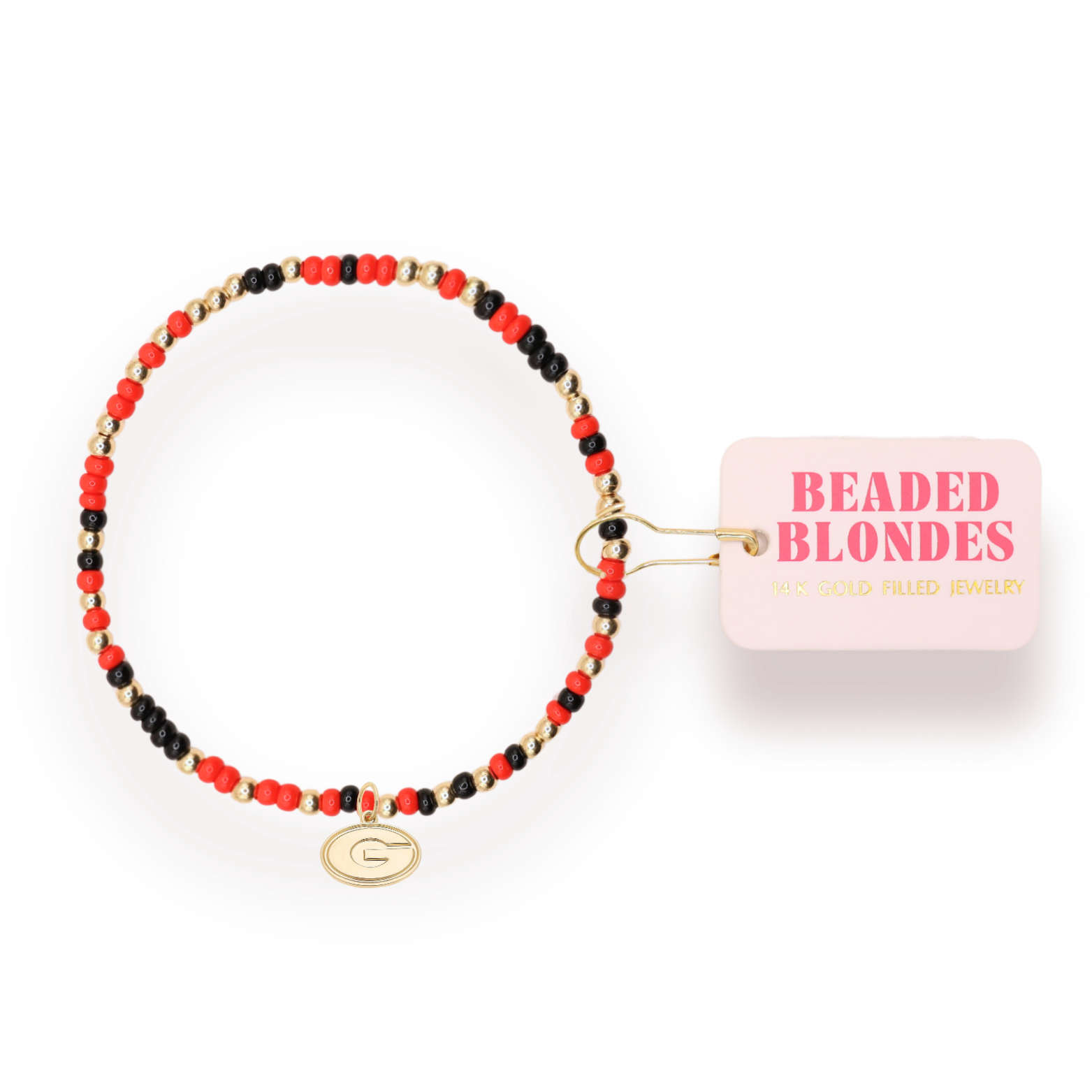 A beaded stretch bracelet with red, black, and gold beads, featuring a gold-toned 'G' initial charm. It is shown with its pink paper tag that reads 'BEADED BLONDES'.