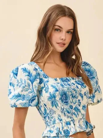 Woman wearing a blue floral top on a beige background