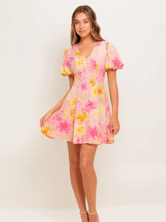 Woman wearing a floral dress with pink and yellow flowers on a white background