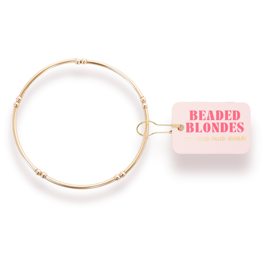 Gold beaded bracelet with 'Beaded Blondes' packaging on a white background