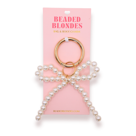 Pearl keychain on a pink 'Beaded Blondes' packaging with gold ring.