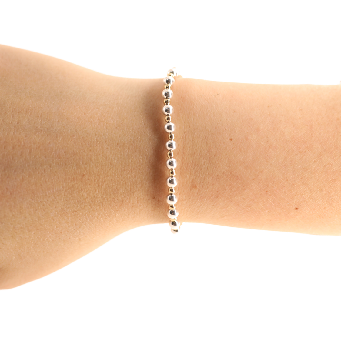 Silver beaded bracelet on a person's wrist against a white background