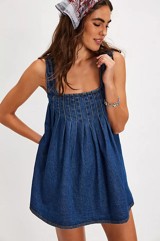Woman wearing a blue denim dress with a white background