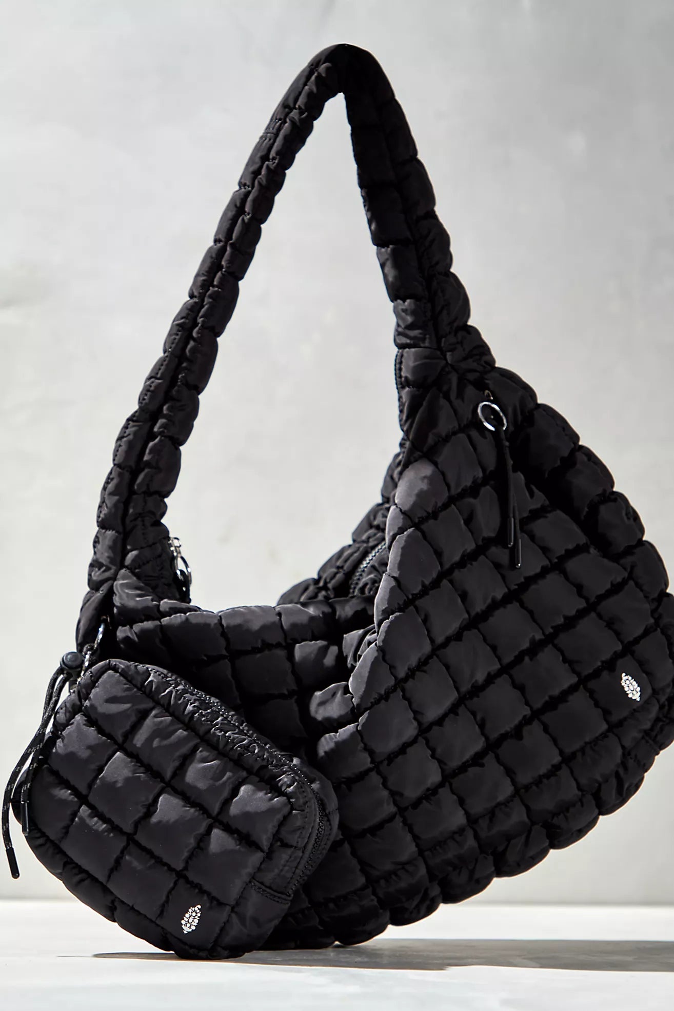 Black quilted handbag on a light gray background