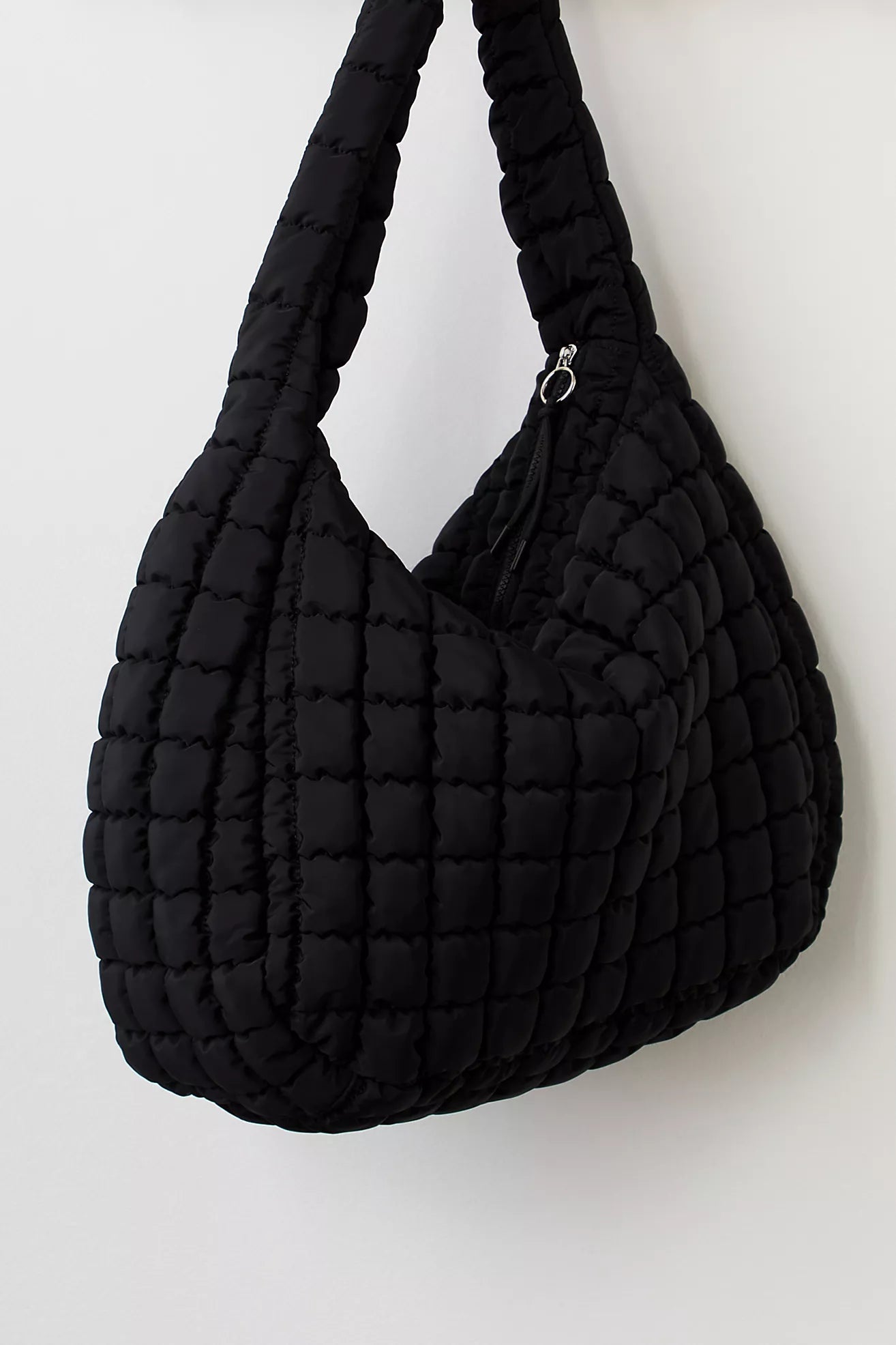 Black quilted handbag on a white background