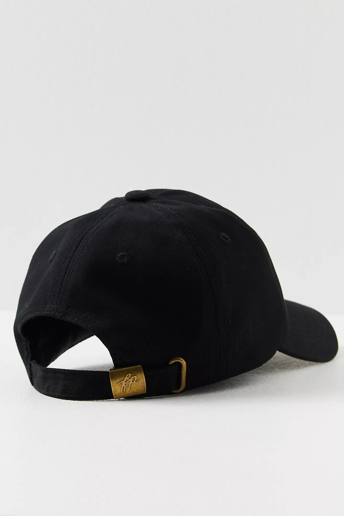 Black cap with a gold tag on a white background