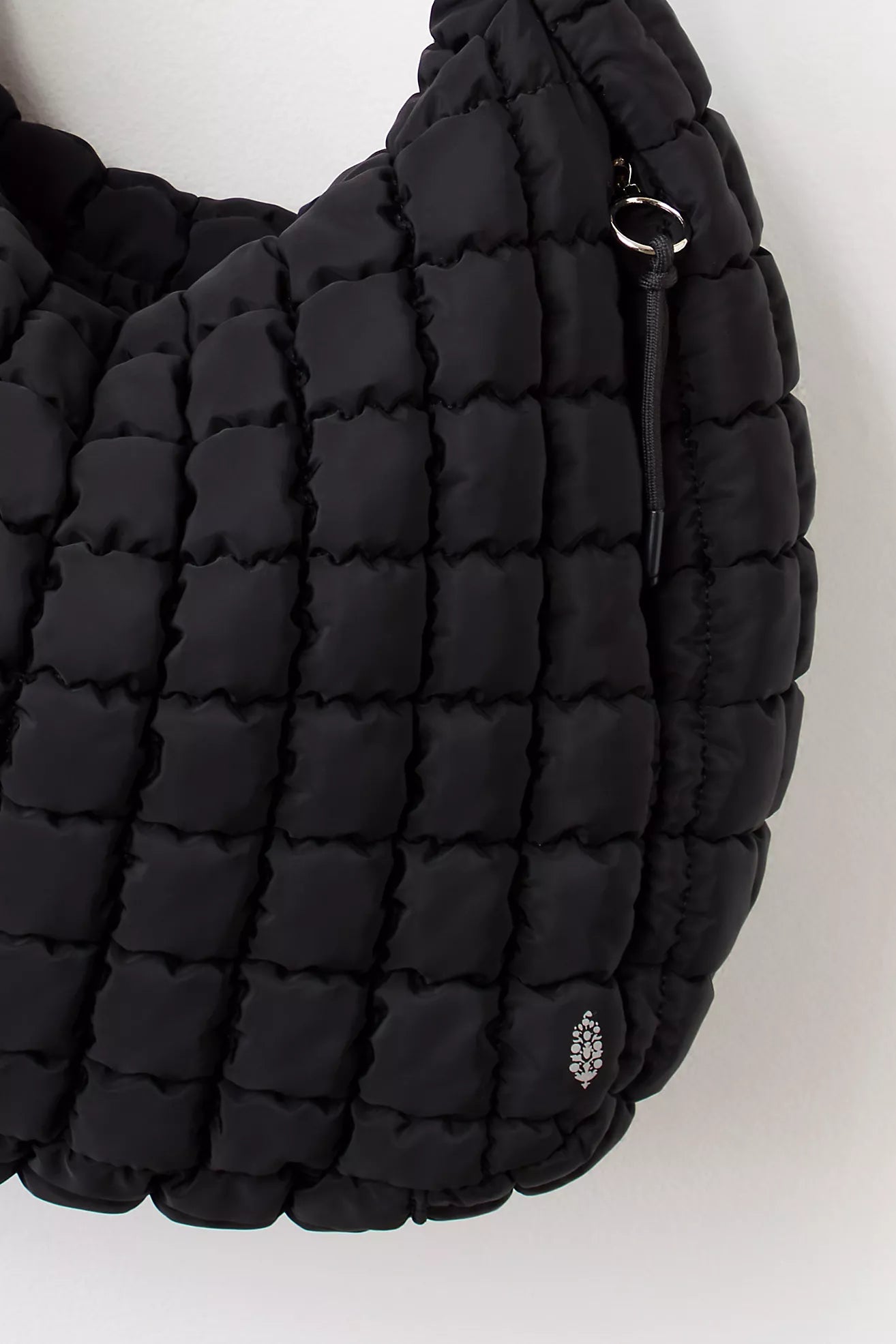 Black quilted handbag on a white background