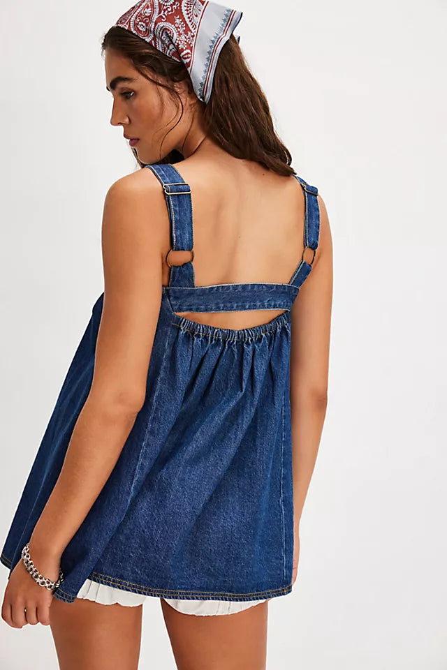 Woman wearing a denim dress with cut-out back on a white background