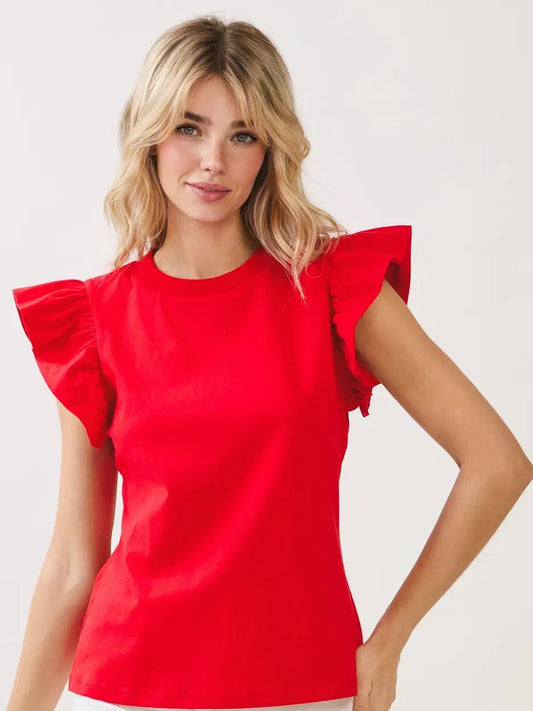 Woman wearing a red top with ruffled sleeves on a light gray background