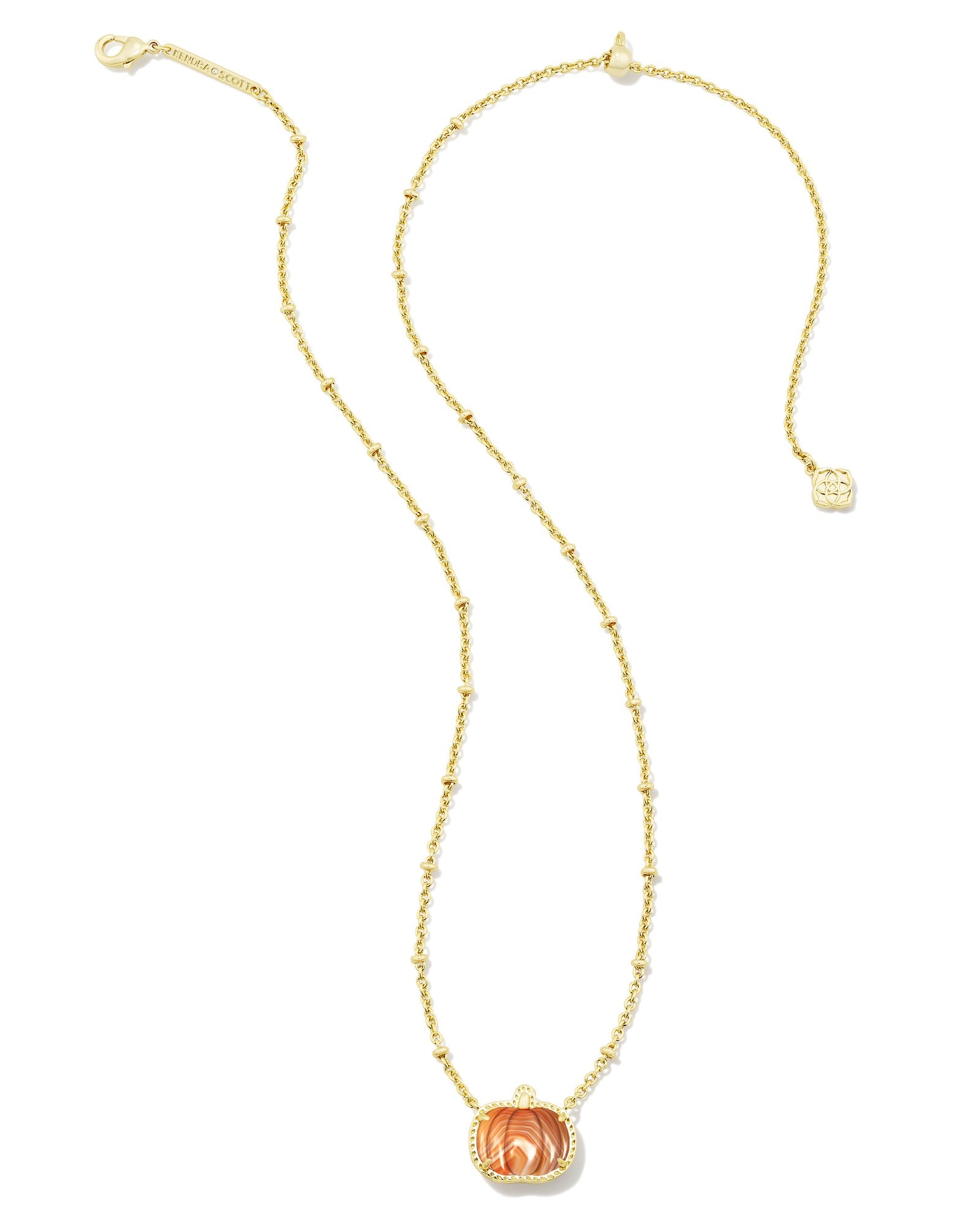 Gold necklace with orange pumpkin pendant on white background including clasps 