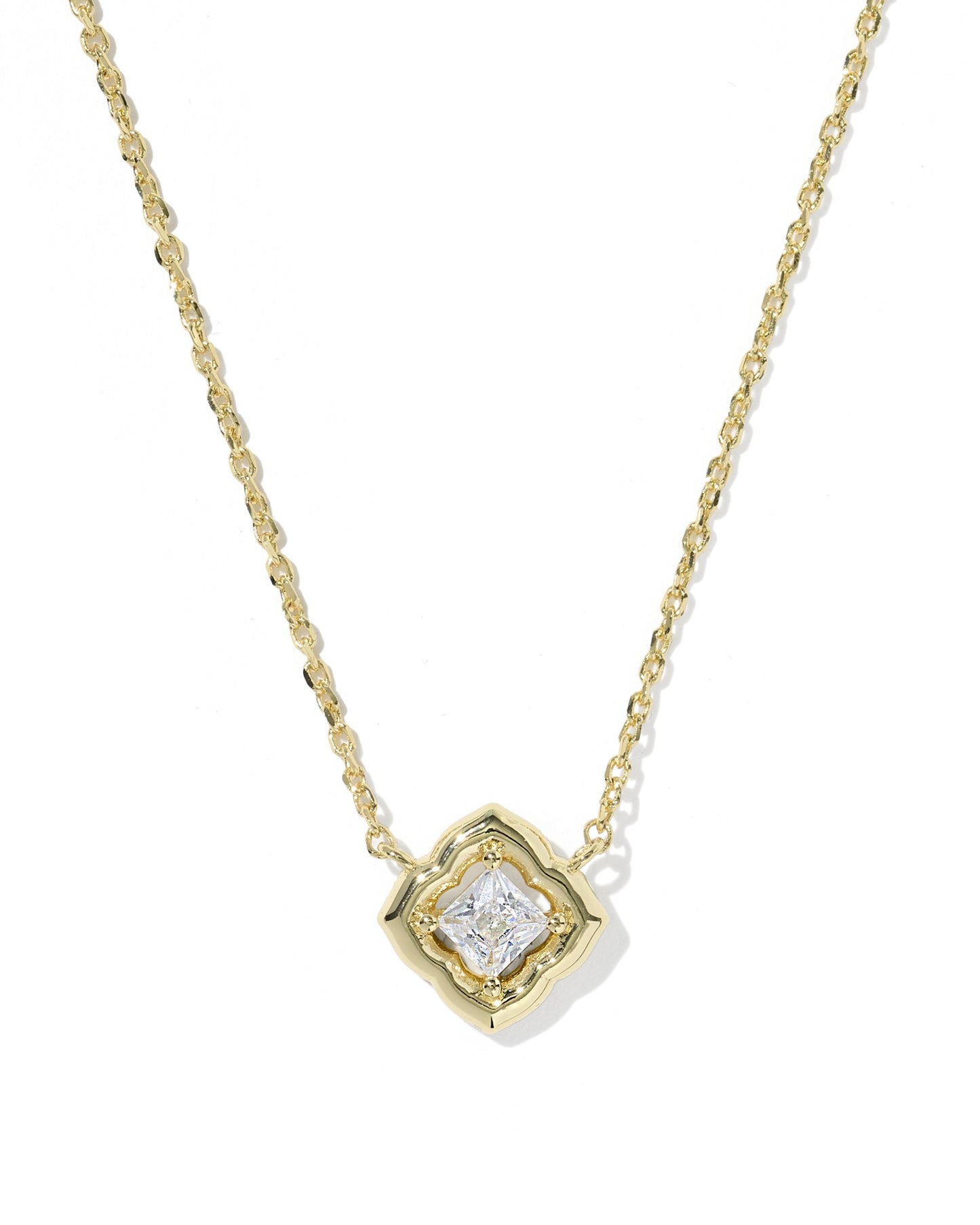 gold necklace with crystal pendant on white background