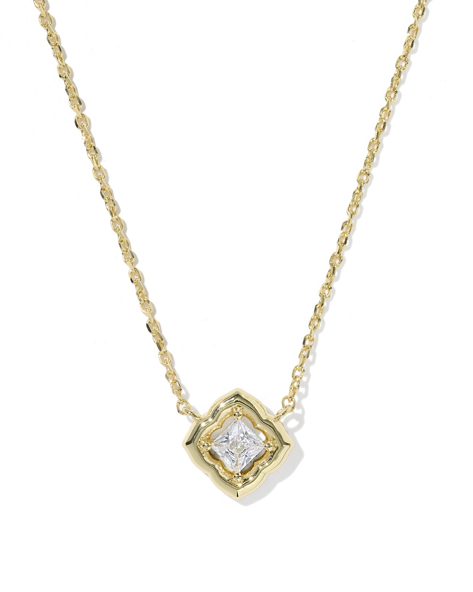 gold necklace with crystal pendant on white background