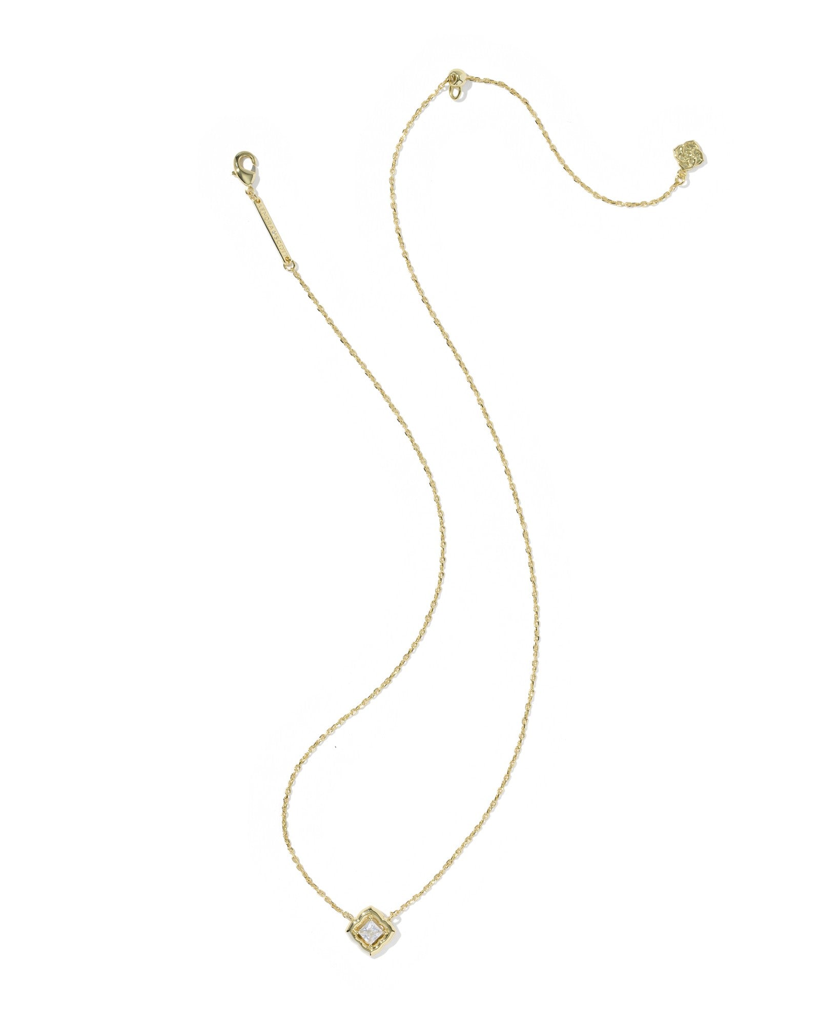 gold necklace with crystal pendant on white background
