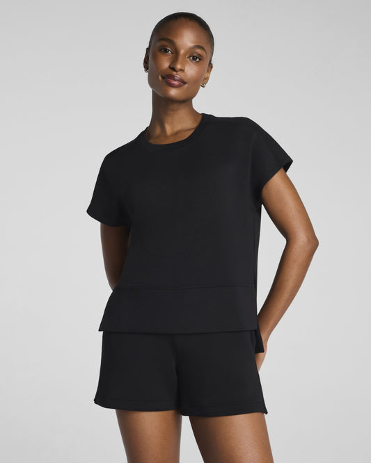 Woman wearing a black outfit with a plain background