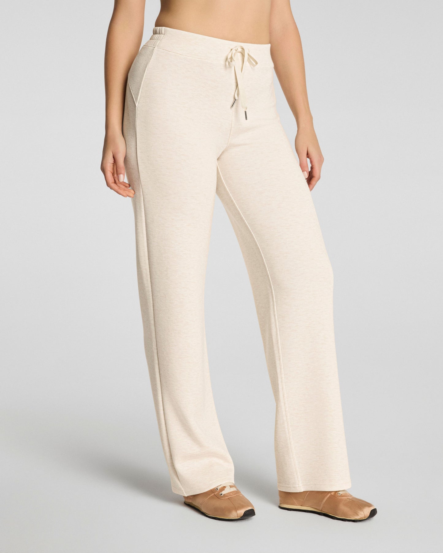 Beige pants worn by a person on a plain background