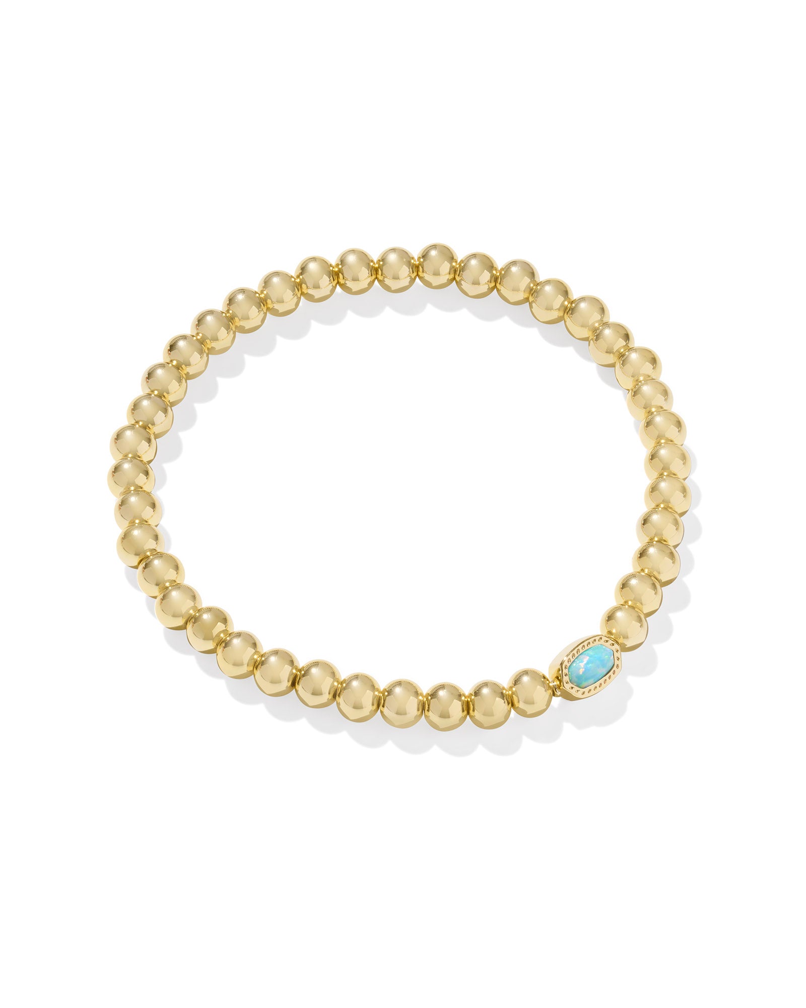 Gold beaded bracelet with a blue gemstone on a white background