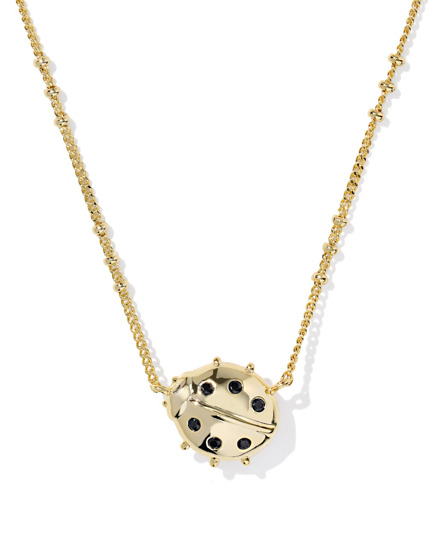 Gold necklace with a ladybug pendant on a white background