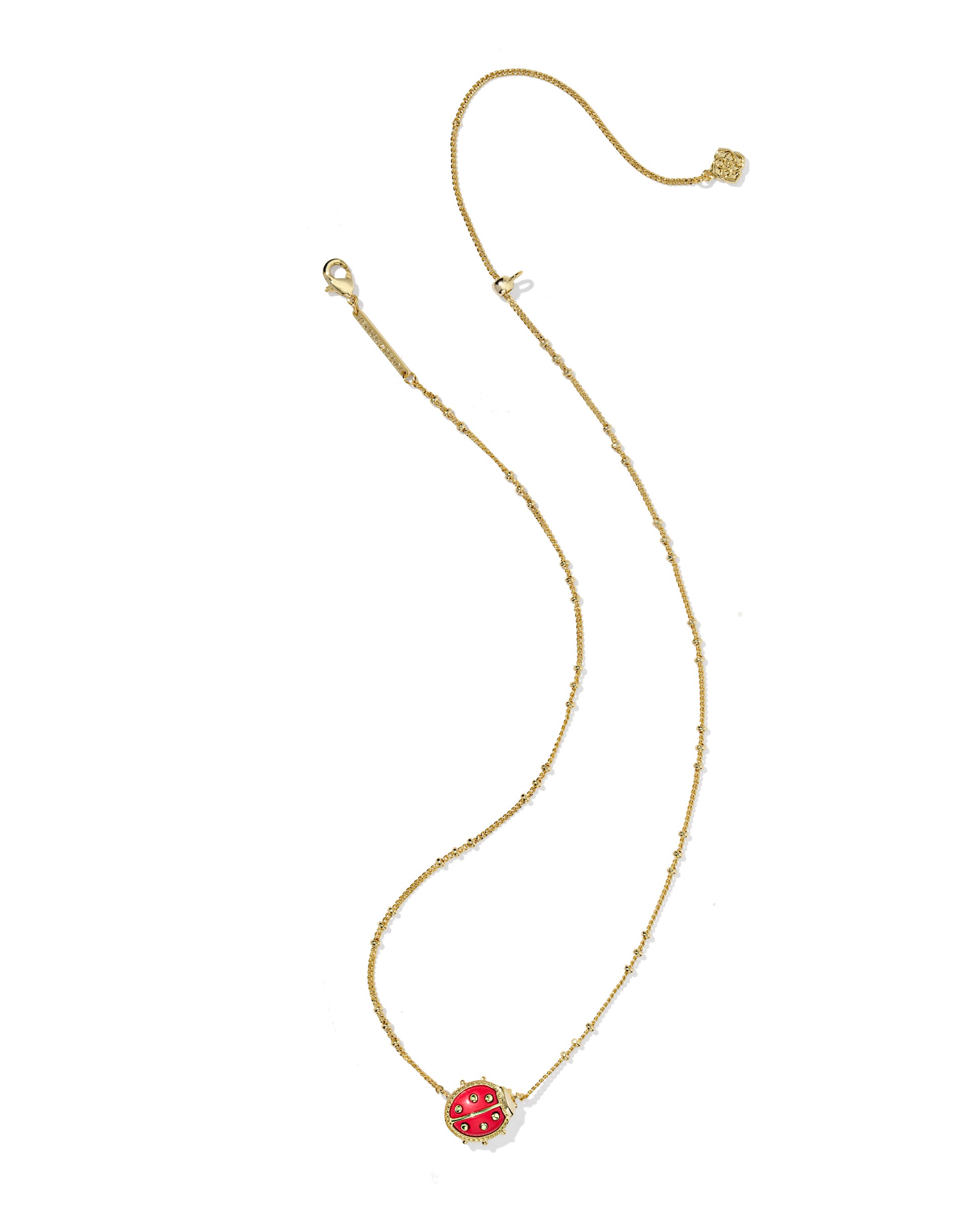 Gold necklace with a red pendant on a white background