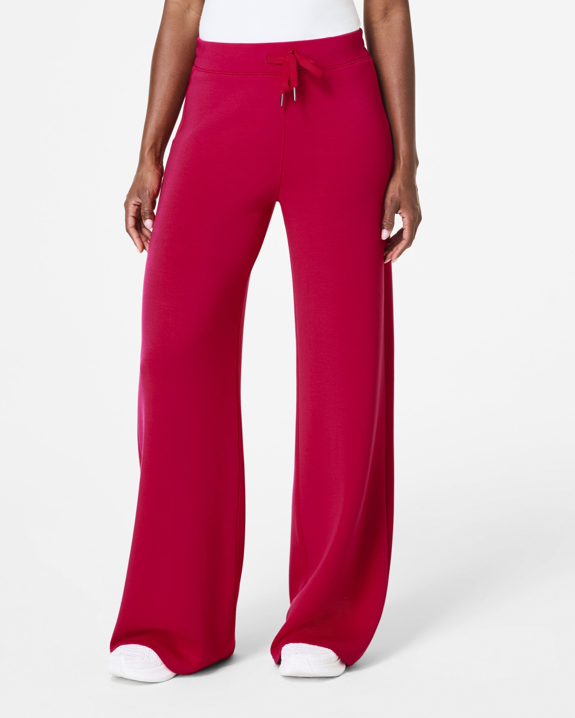 Model standing facing forward with pink spanx pants 