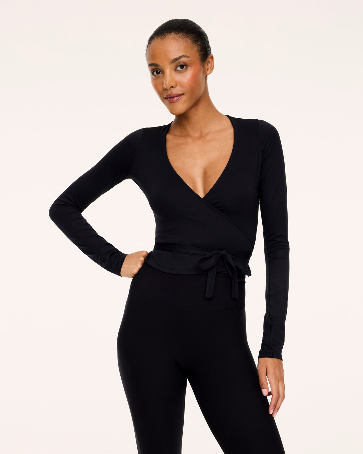 Woman wearing Spanx Ballet Wrap Top in Black with white background