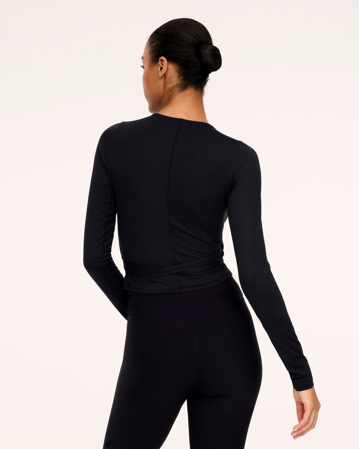 Woman wearing Spanx Ballet Wrap Top in Black with white background