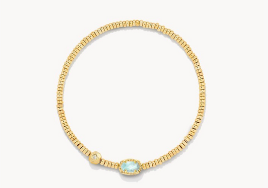 Gold bracelet with a central blue gemstone on a white background
